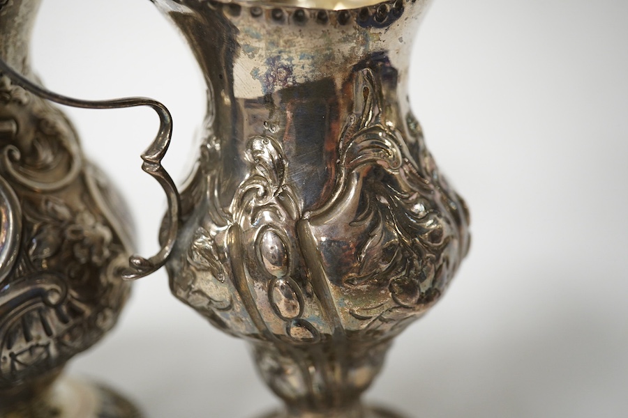 Two Georgian silver cream jugs, with later embossed decoration, inverted pyriform, London, 1782, the other London, 1773 (a.f.). Condition - poor to fair
